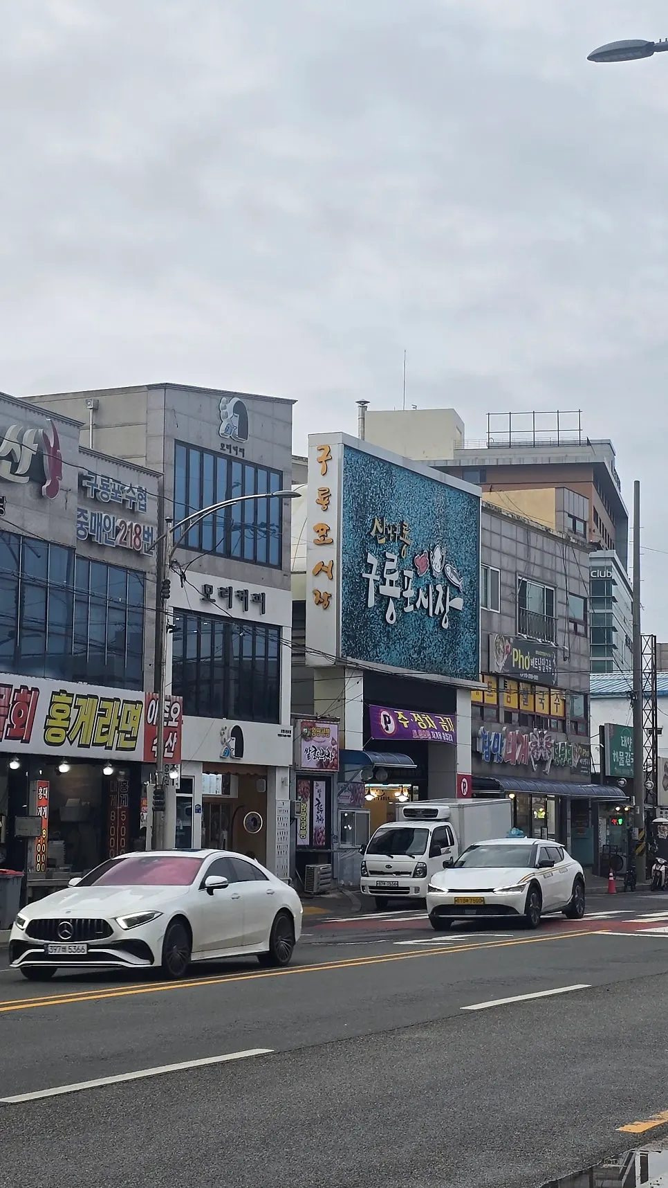 A street in Guryongpo Market lined with crab and sashimi signs