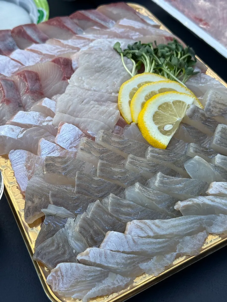 Thick assorted sashimi topped with lemon and radish sprouts