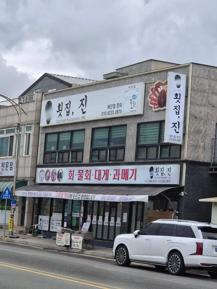 Exterior of Hoetjip Jin in Guryongpo with a white signboard