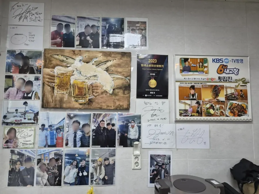 Wall covered with TV appearances and celebrity visit mementos