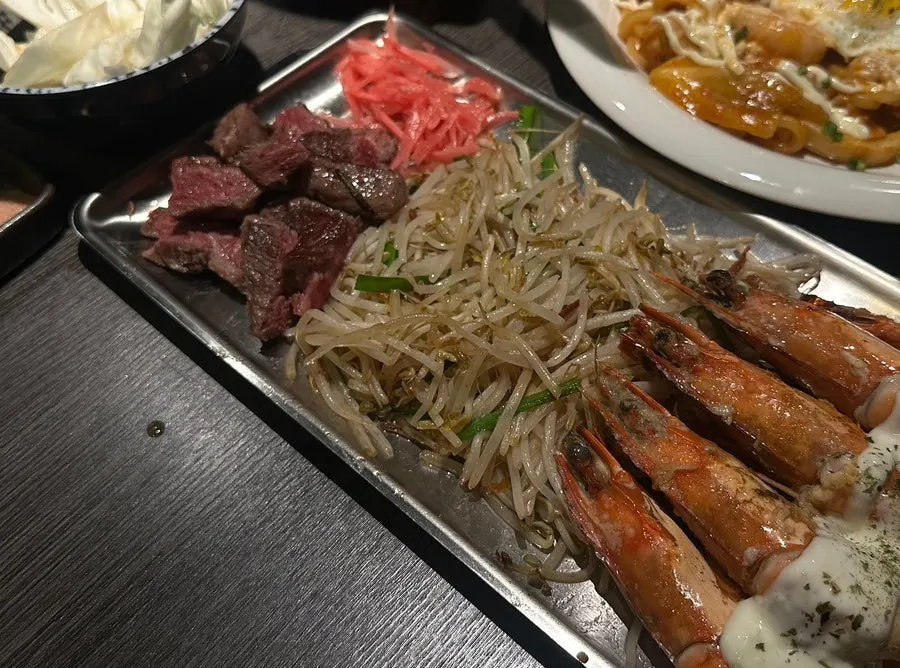 바 좌석 앞 철판에서 고기를 굽는 모습