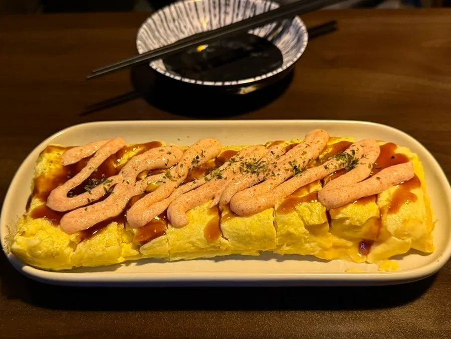 소스가 뿌려진 명란치즈계란말이 접시