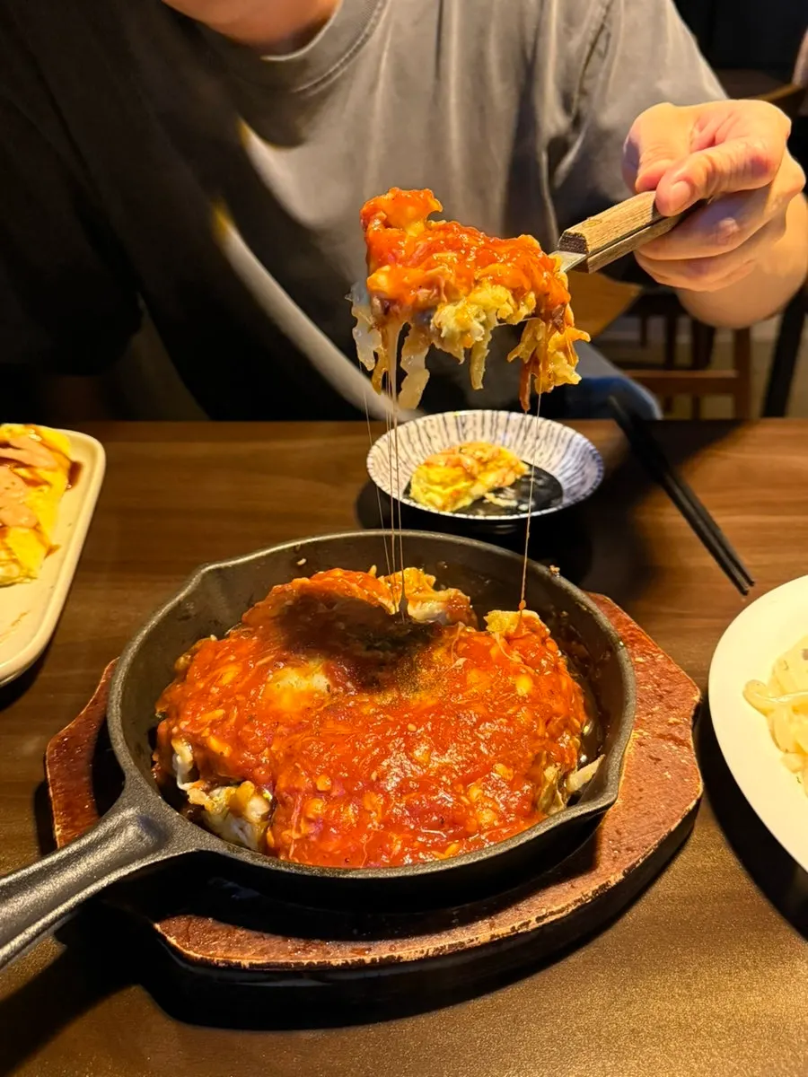 계란말이 한 조각을 집어 든 모습