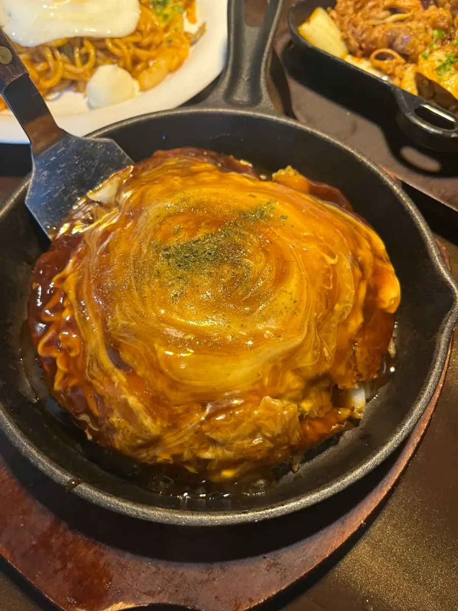 Okonomiyaki topped generously with sauce
