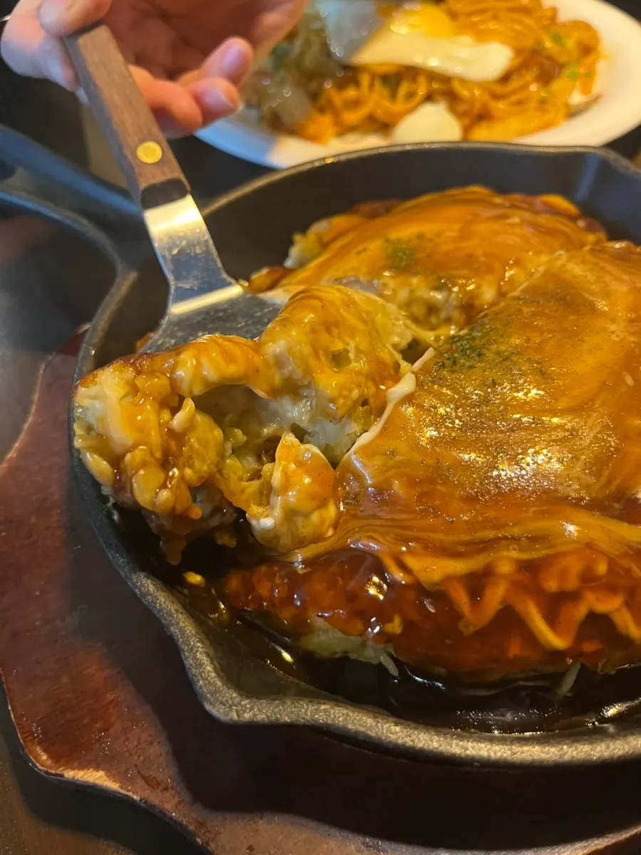 A slice of okonomiyaki grilled on the teppan