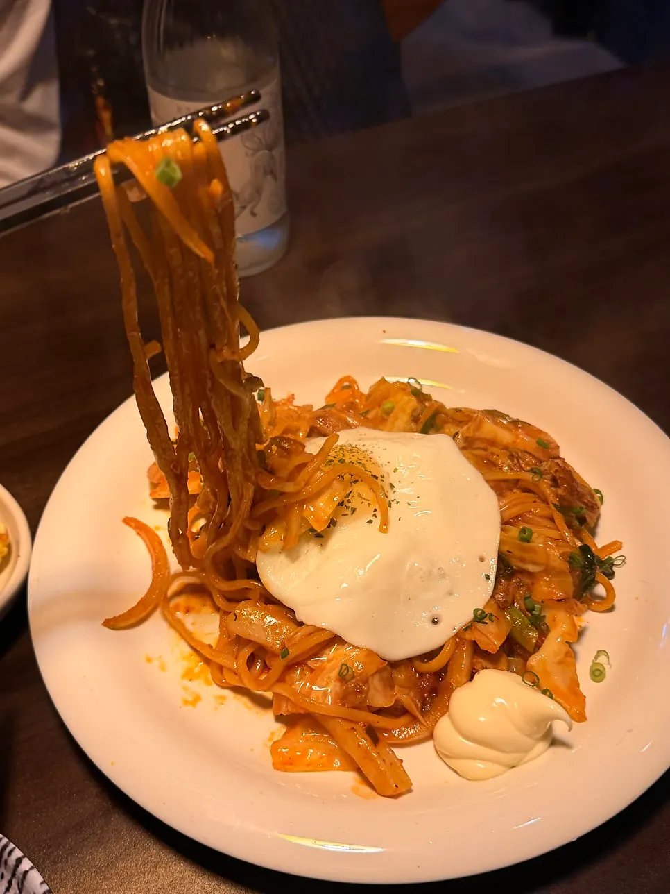 Noodles lifted from a plate of karai yakisoba