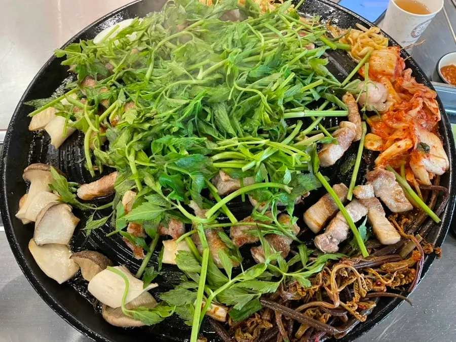 Minari and meat grilling on the cast-iron lid