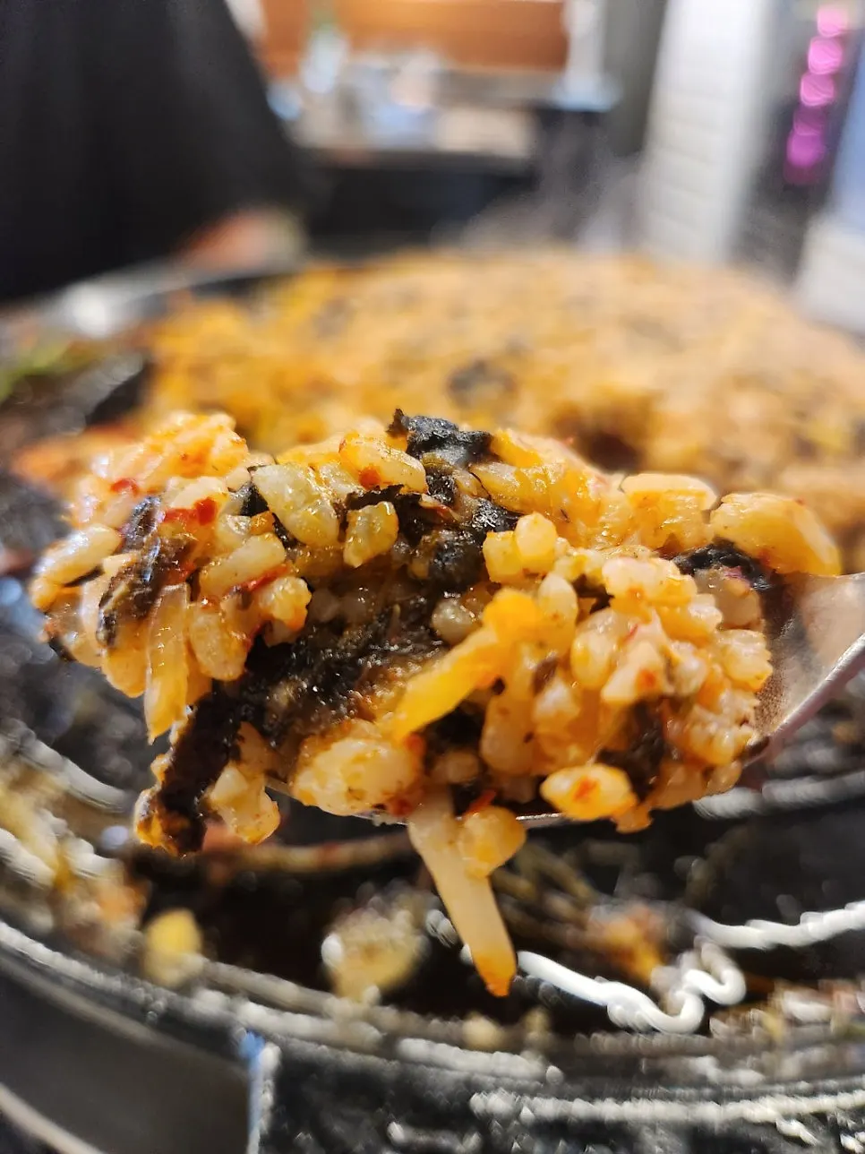 Two servings of kimchi fried rice being stir-fried on the grill