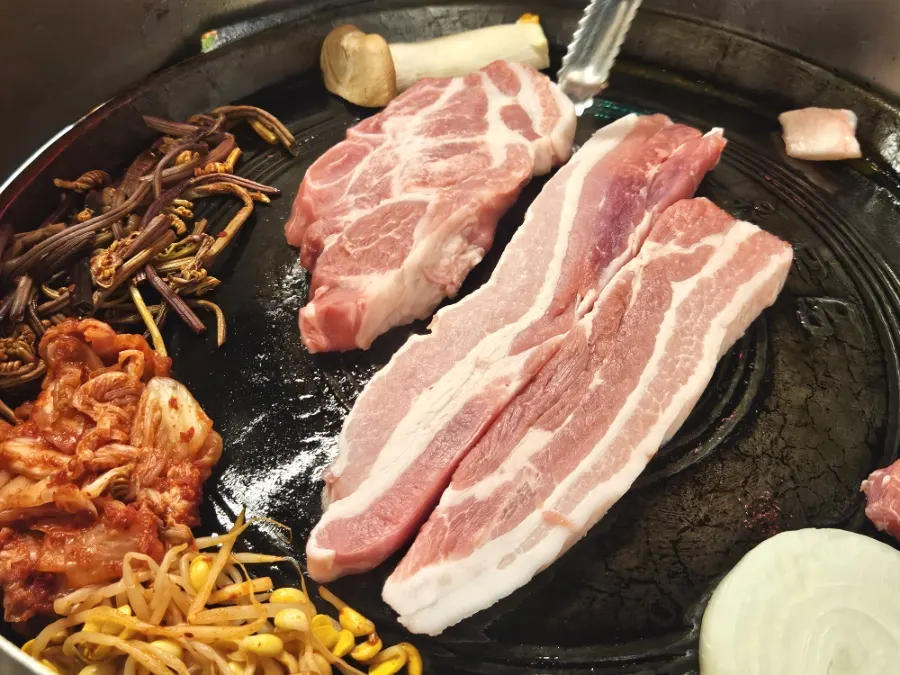 Minari and kimchi placed over the meat