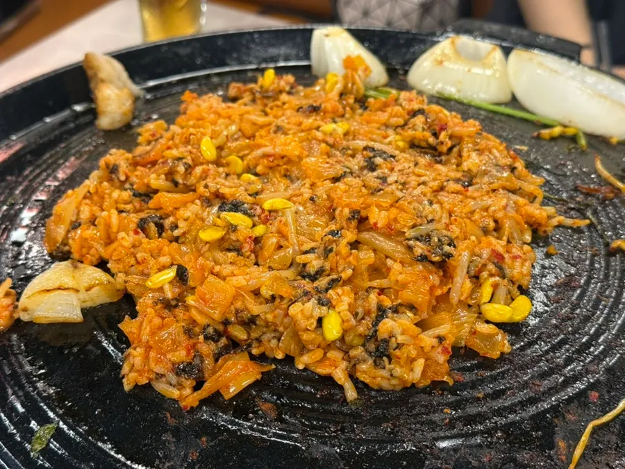Kimchi and bean sprout fried rice stir-fried on a pot lid
