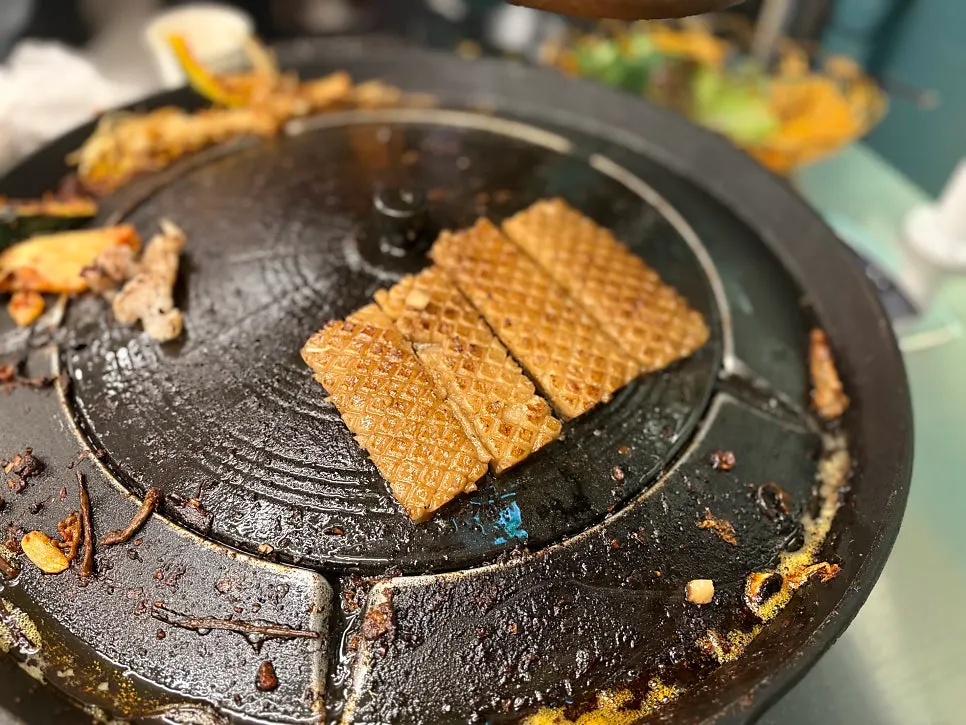 Pork skin grilling at the edge of the plate