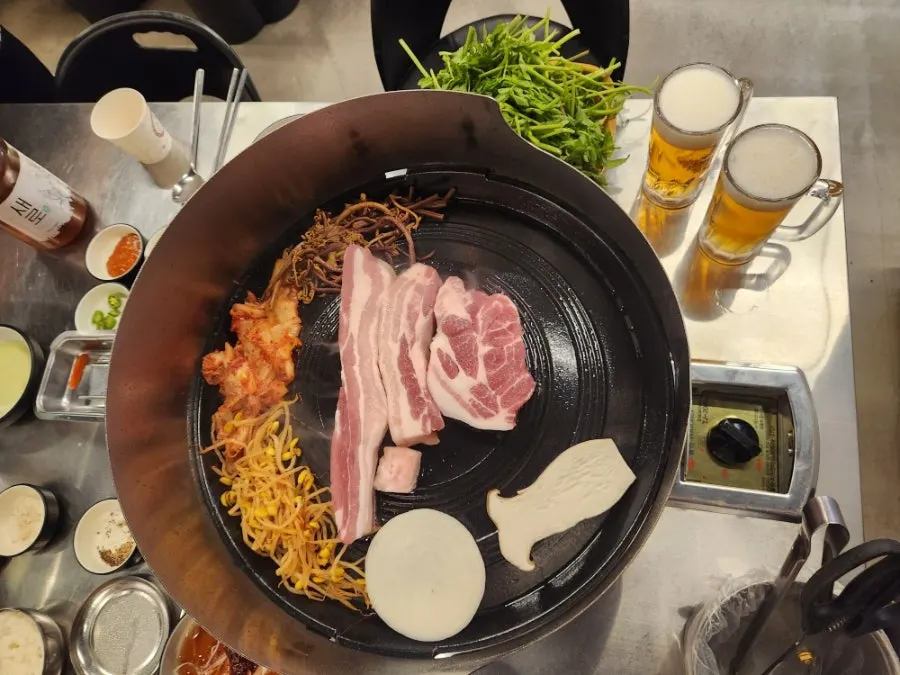 Pork belly and kimchi cooking on the 270°C cauldron lid
