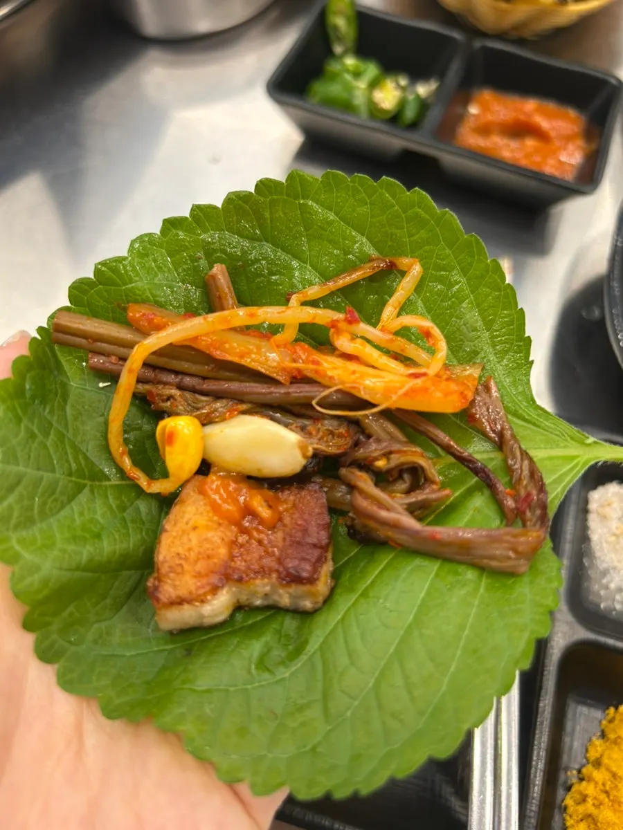 Pork belly eaten with accompaniments
