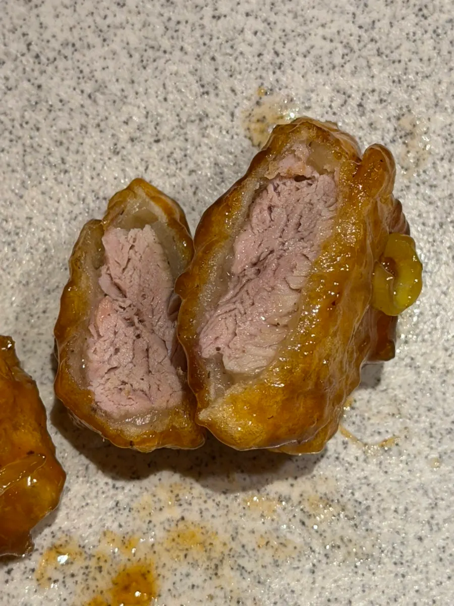 A piece of sweet and sour pork topped with fresh wasabi