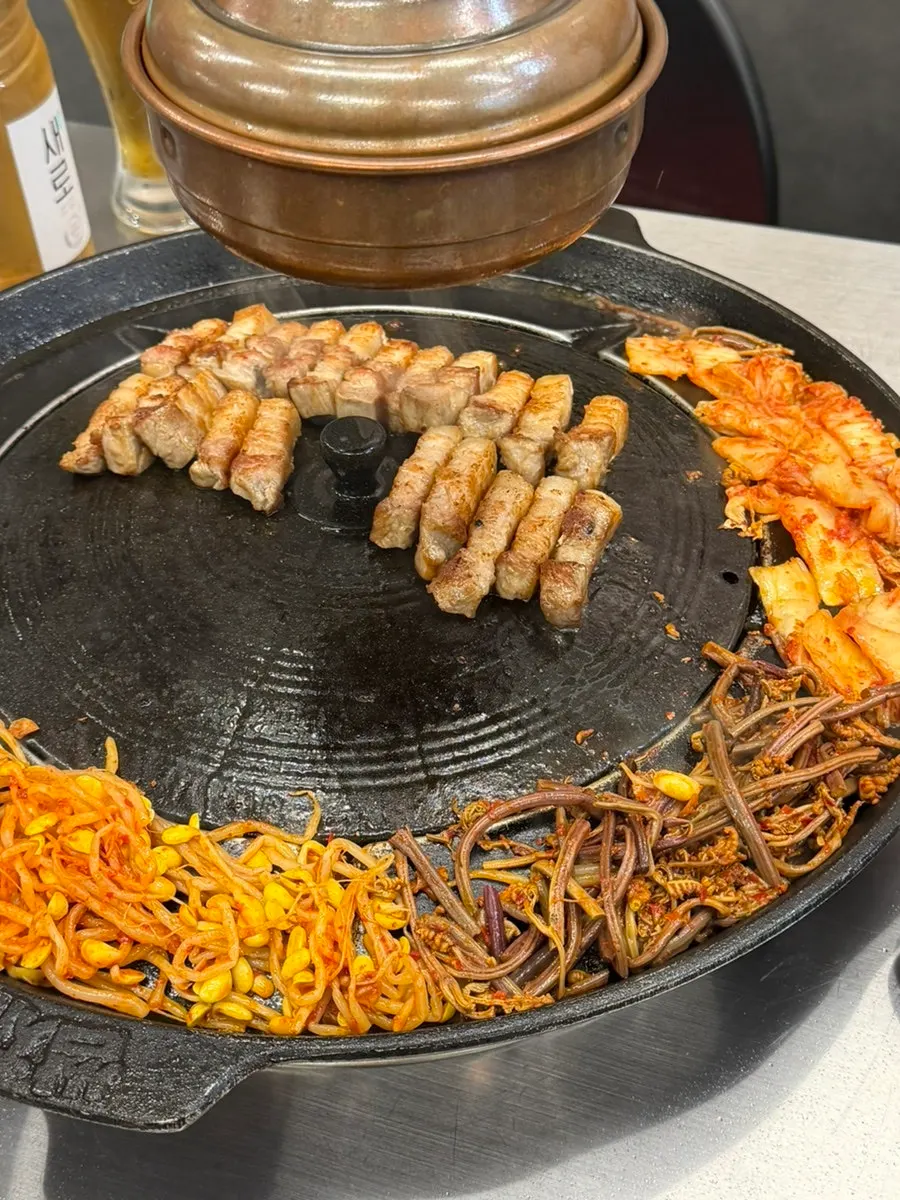 釜蓋の端で焼けていくキムチ