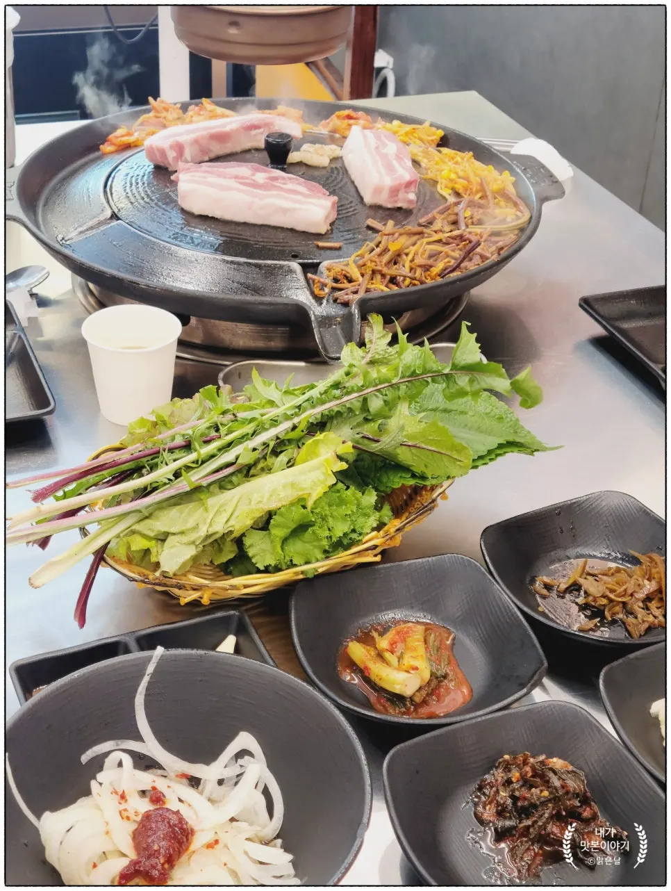 Full table spread of side dishes and wrap greens