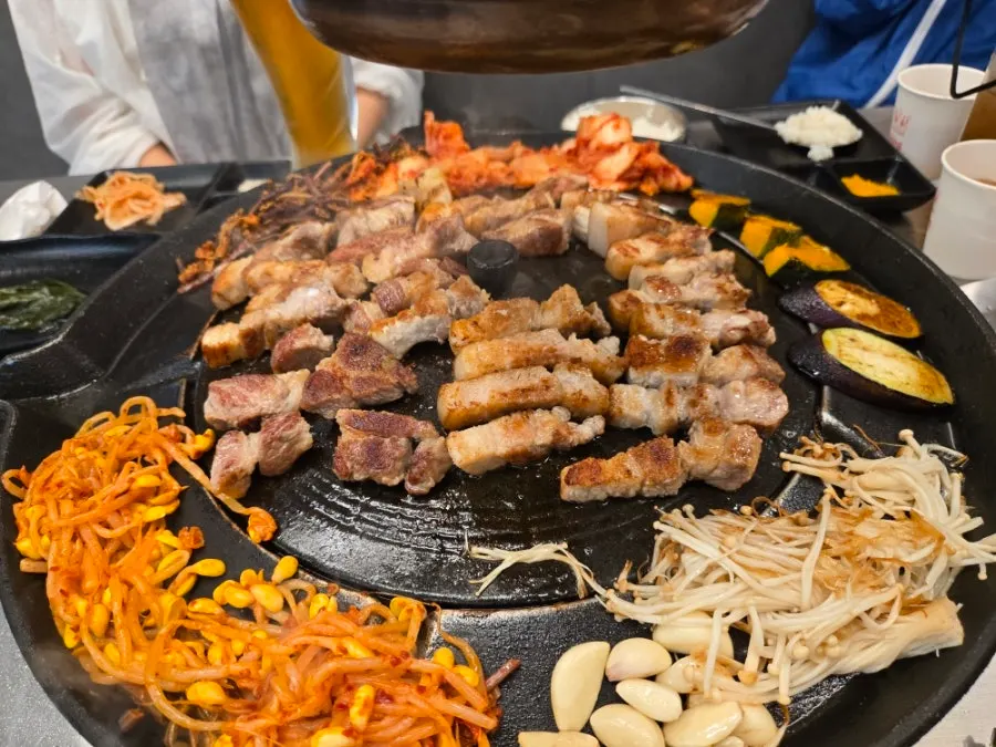쌈채소에 삼겹살과 김치, 마늘을 올린 쌈
