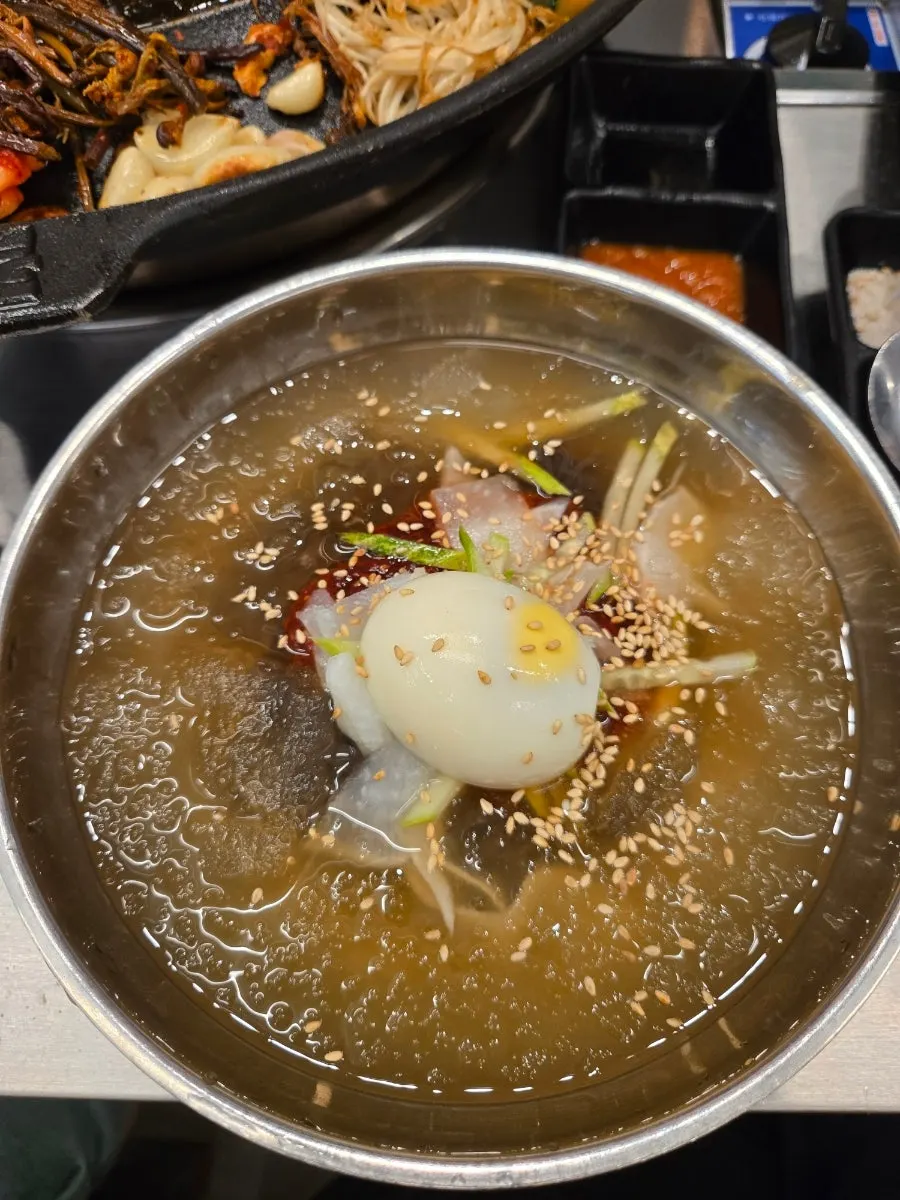 고기 위에 올린 물냉면 한 젓가락