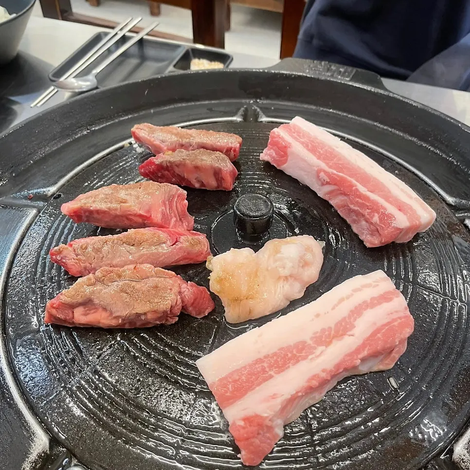 솥뚜껑에 올린 삼겹살과 황제소갈비살