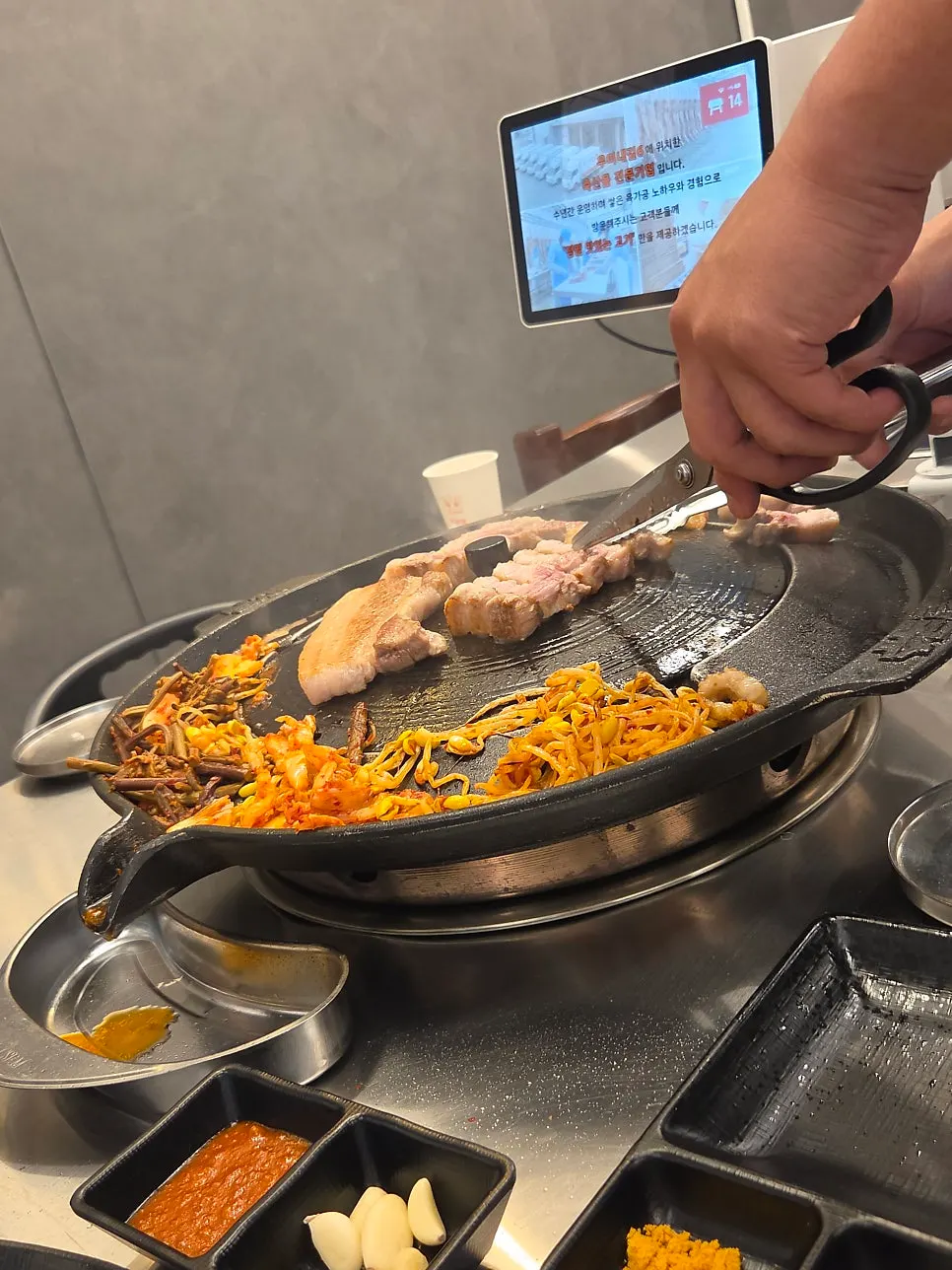 Pork belly cooking on the iron lid grill