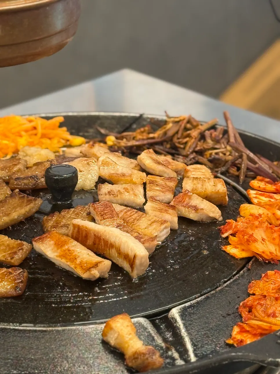 Close-up of pork jowl as it cooks