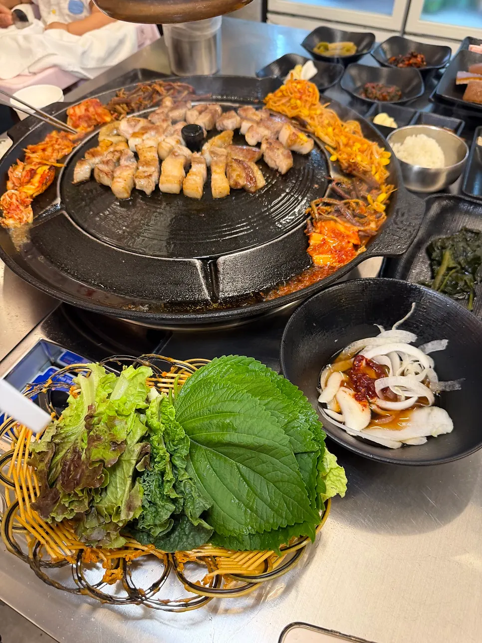 솥뚜껑 위에서 노릇하게 익어가는 삼겹살과 목살