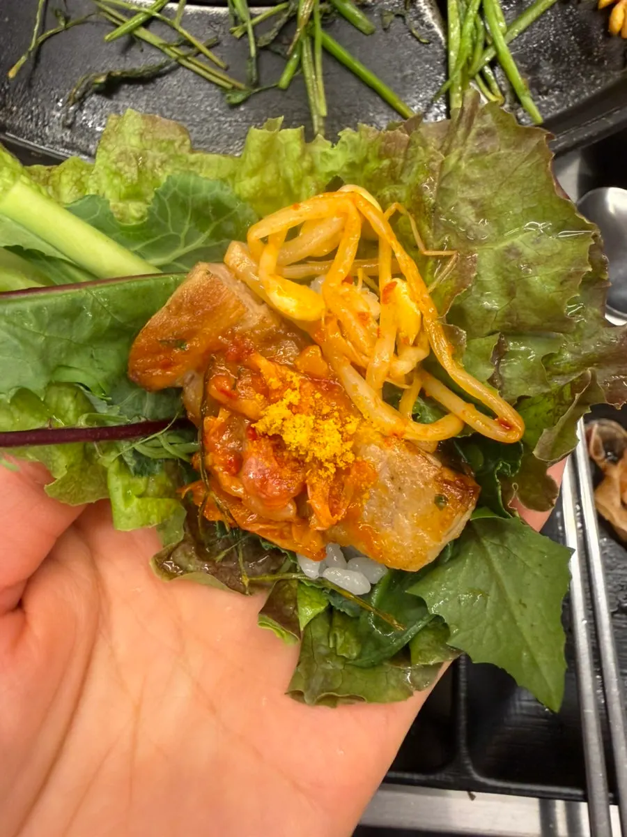 명이나물에 싼 삼겹살 한 점