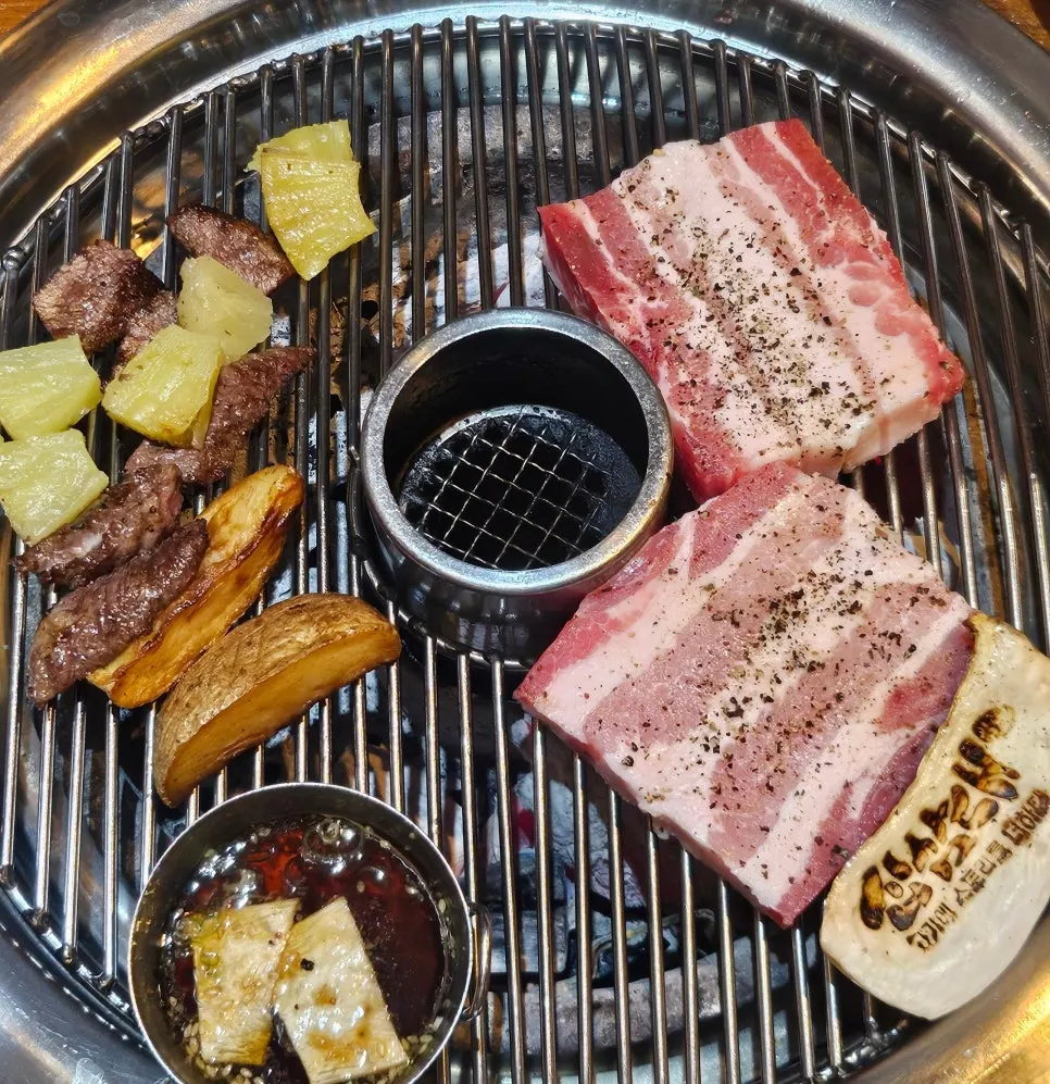 Meat and side vegetables moved to one side of the grill