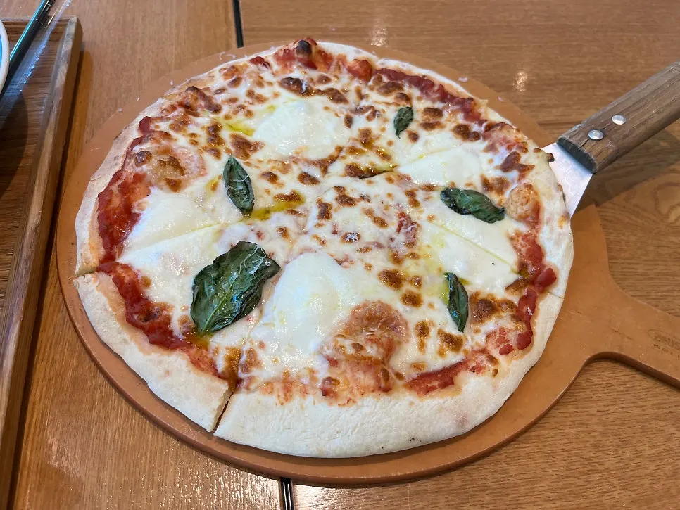 Pizza, pasta, ensalada y dos cafés servidos juntos
