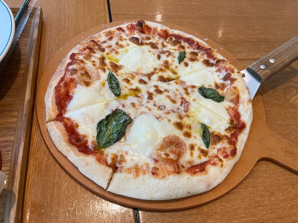 Porción de pizza margherita con el queso estirándose