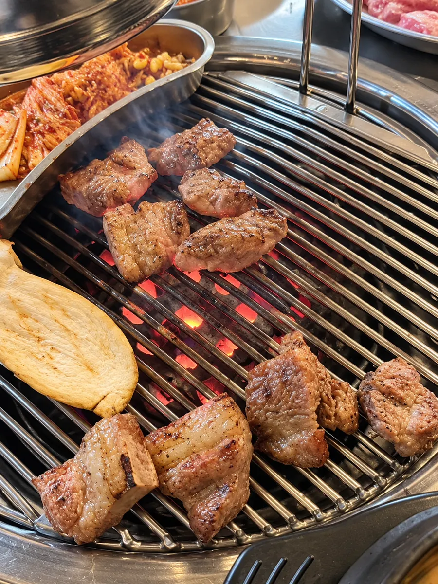 Pork neck grilling over the charcoal fire