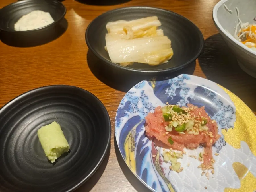 Plate of side dishes including salted pollack roe and white kimchi