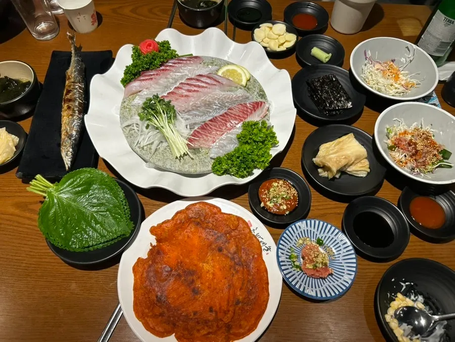 Mesa con sukkidashi básico que incluye hueva de abadejo, sopa de algas y ensalada de pescado crudo