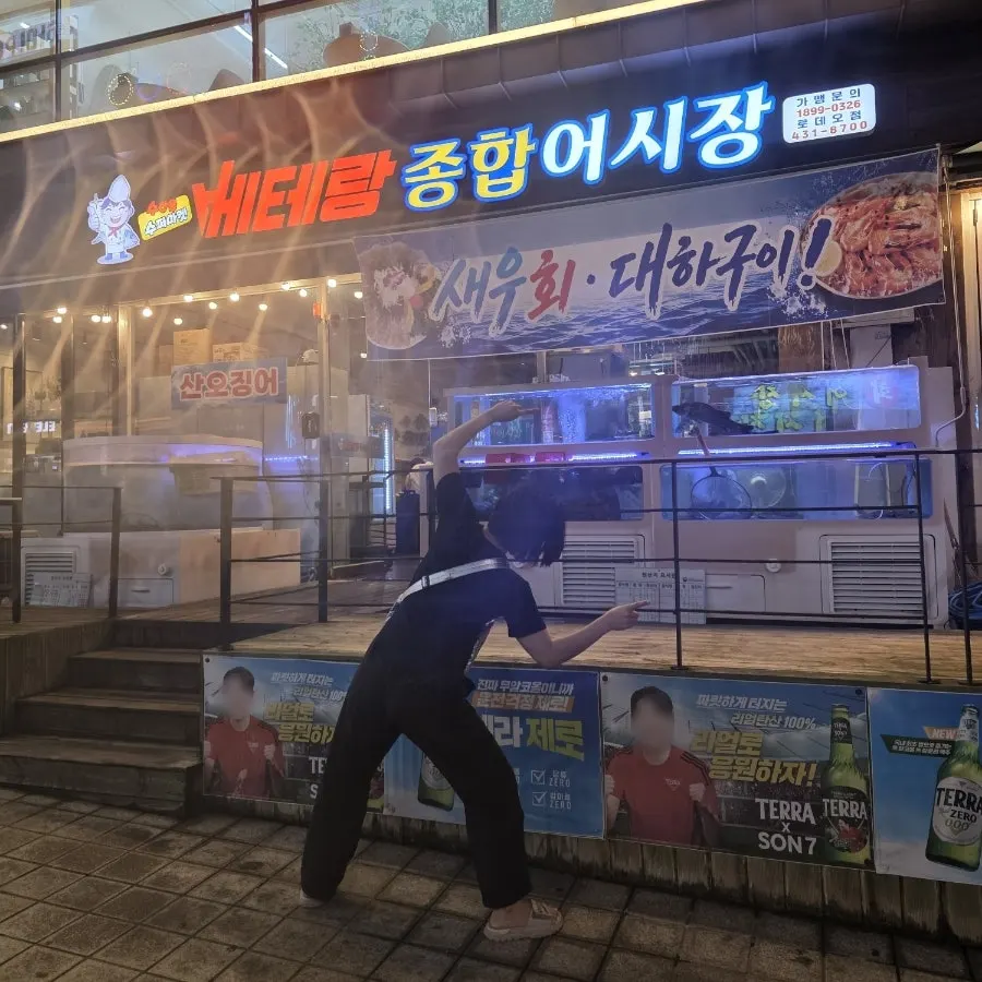 A friend posing outside Veteran General Fish Market Incheon Guwol Branch