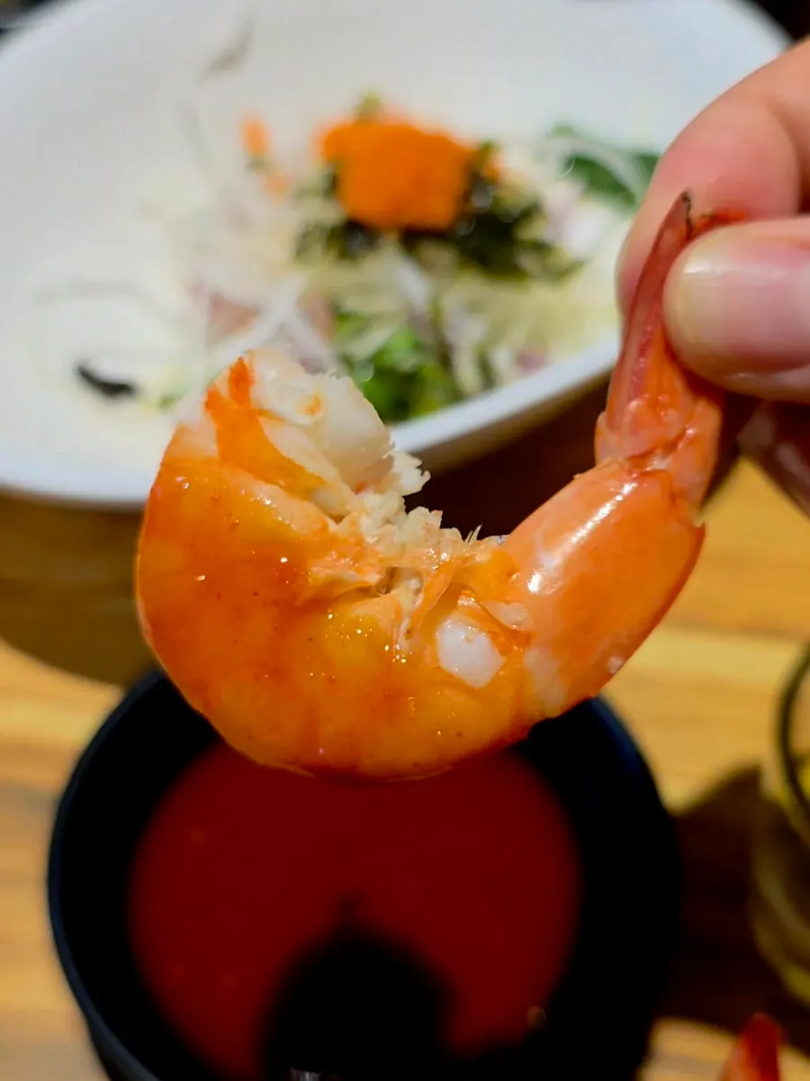 A single salt-grilled shrimp held up