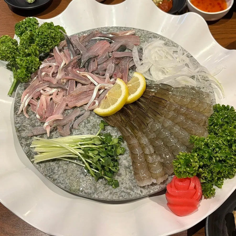 Table setting with raw shrimp sashimi and live fish half-and-half