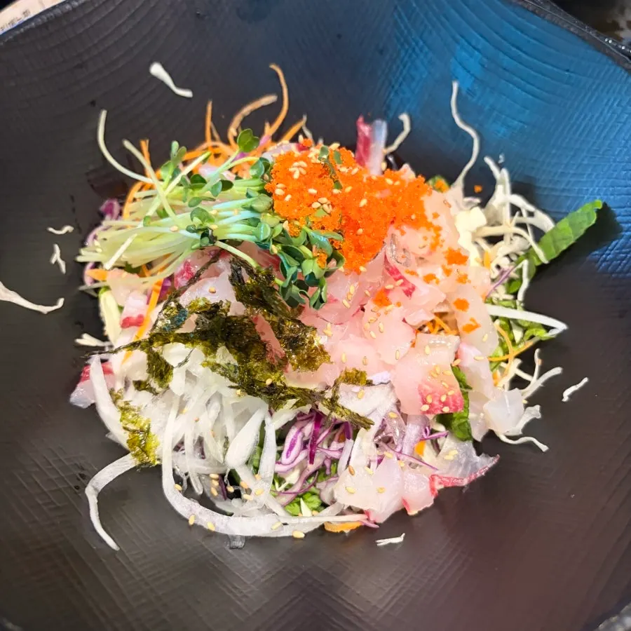 Hoedeopbap topped with vegetables, flying fish roe and sashimi