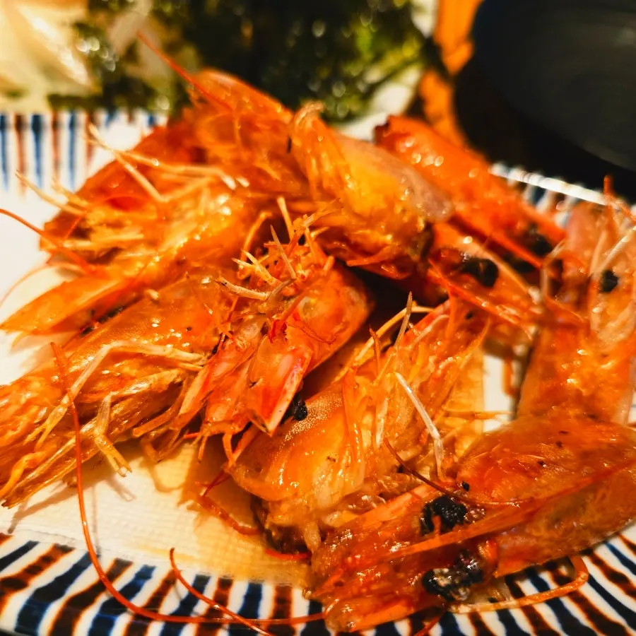 Plate of raw shrimp sashimi and butter-grilled shrimp heads