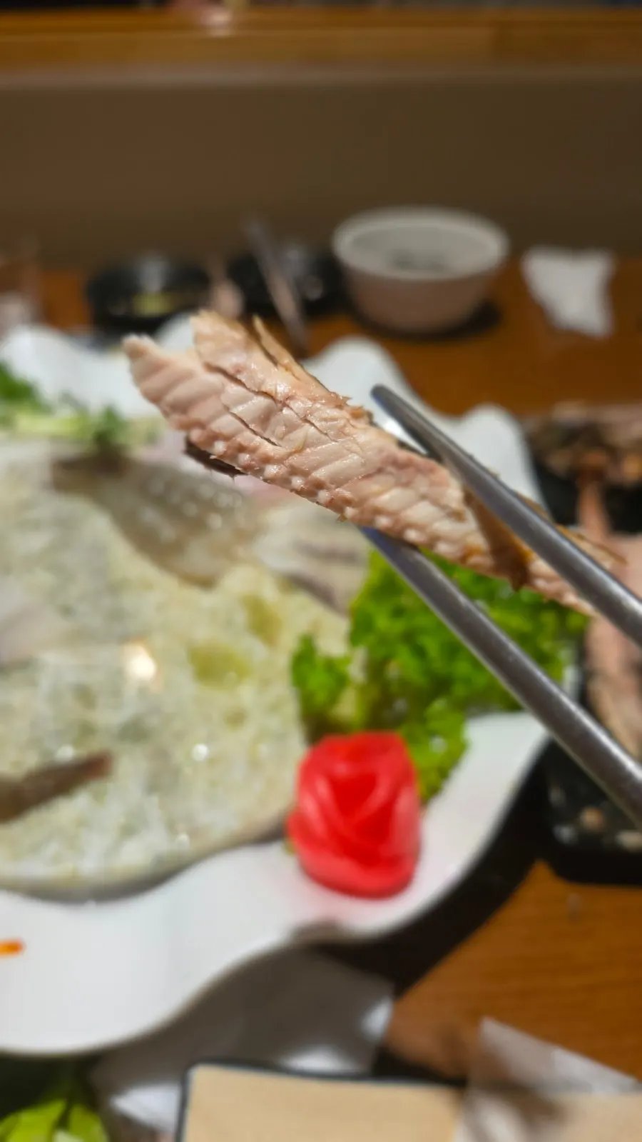 A piece of red snapper sashimi with wrap ingredients