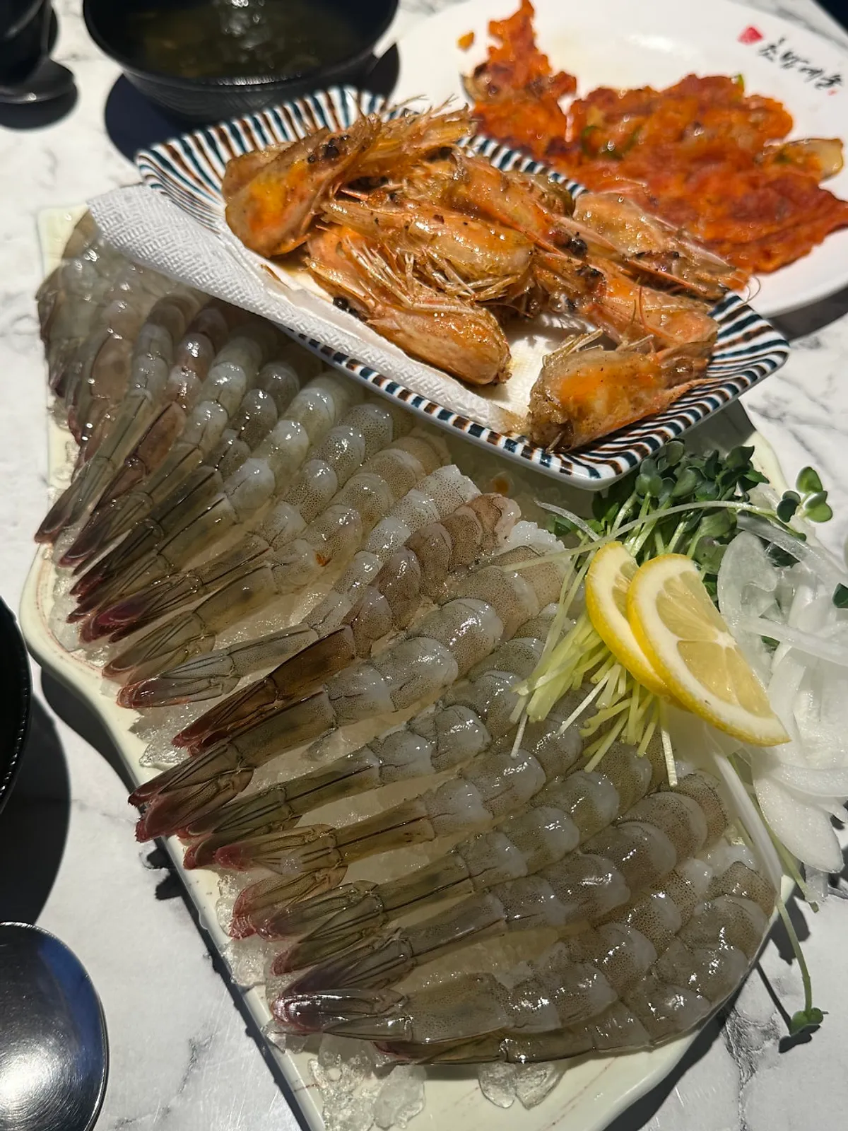 Prepared raw shrimp sashimi with grilled shrimp heads