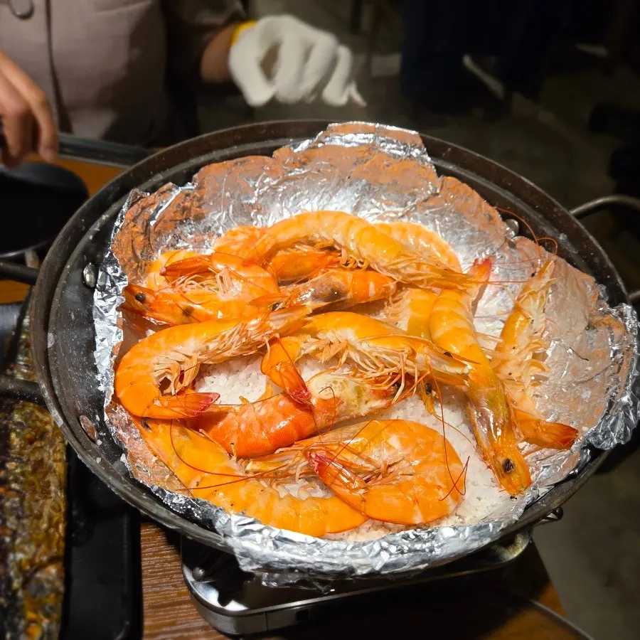 Picking up a piece of warm salt-grilled shrimp