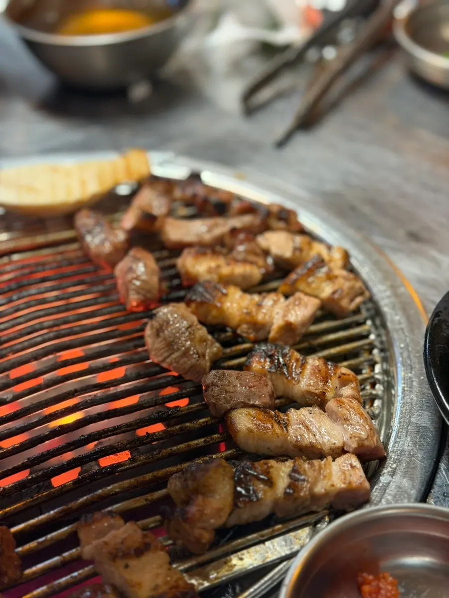 연탄불 위 고기와 찌개까지 놓인 테이블