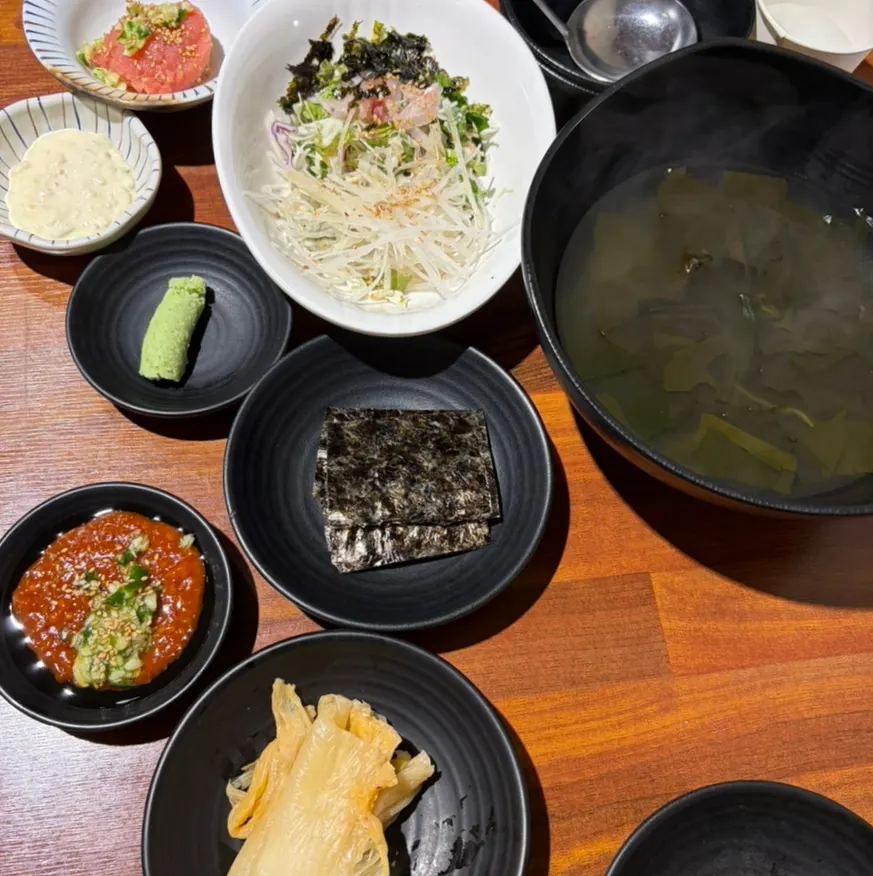 Basic table setting with seaweed soup and mini seasoned raw fish salad