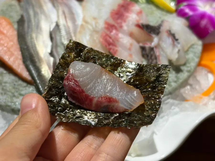 A piece of flounder sashimi dipped in chojang