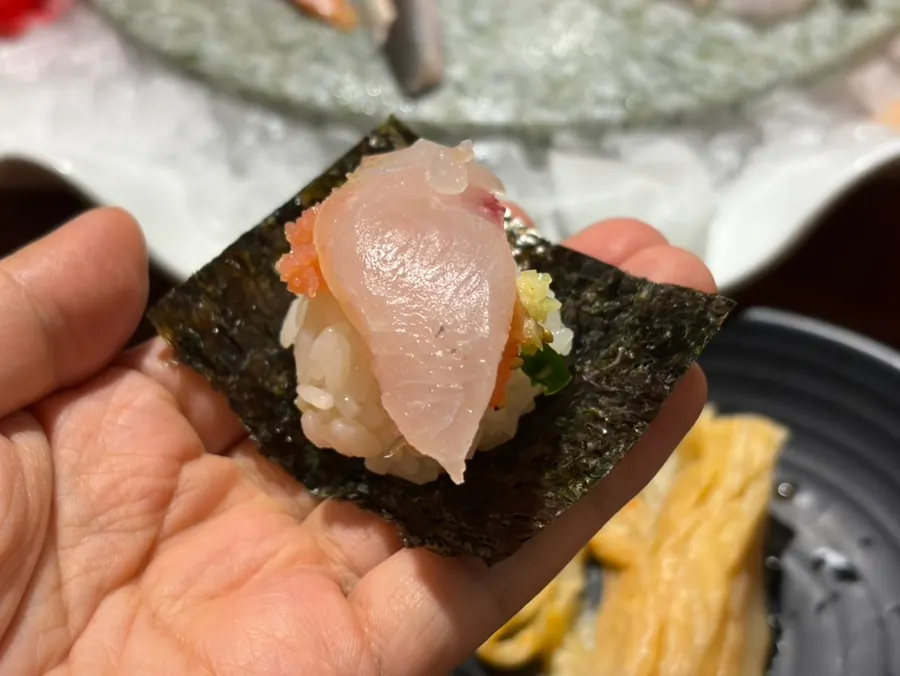 Sushi rice topped with salmon sashimi, onion and sauce