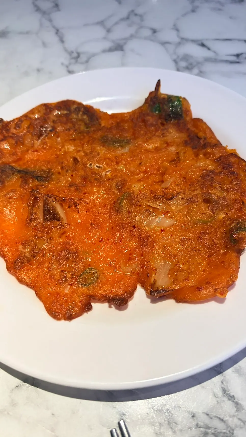 Frying a kimchi pancake by hand