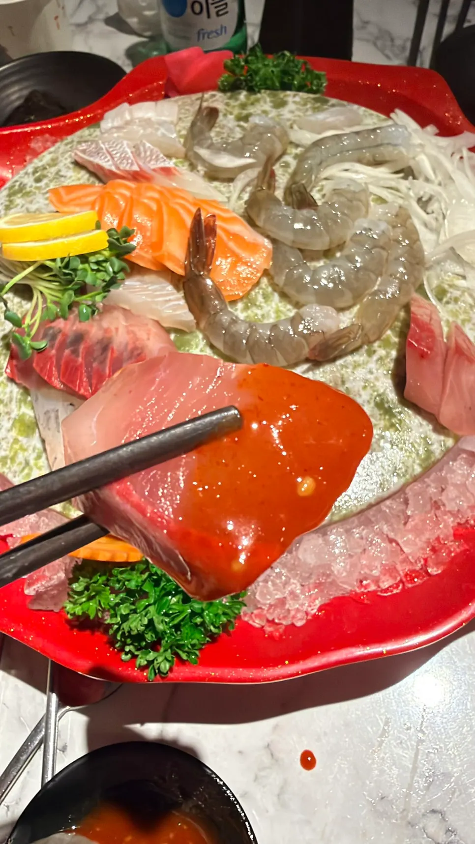 A piece of assorted sashimi dipped in chojang