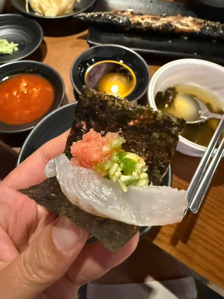 A piece of flounder sashimi with garlic and chili