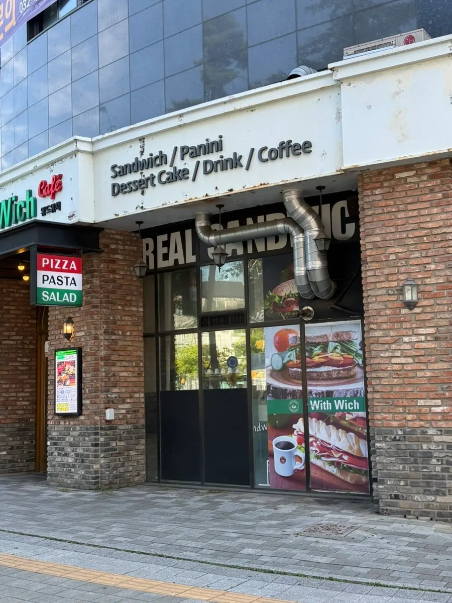 Storefront entrance with the With Wich sign visible
