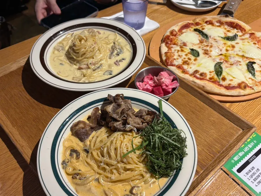A full table spread of pizza and pasta